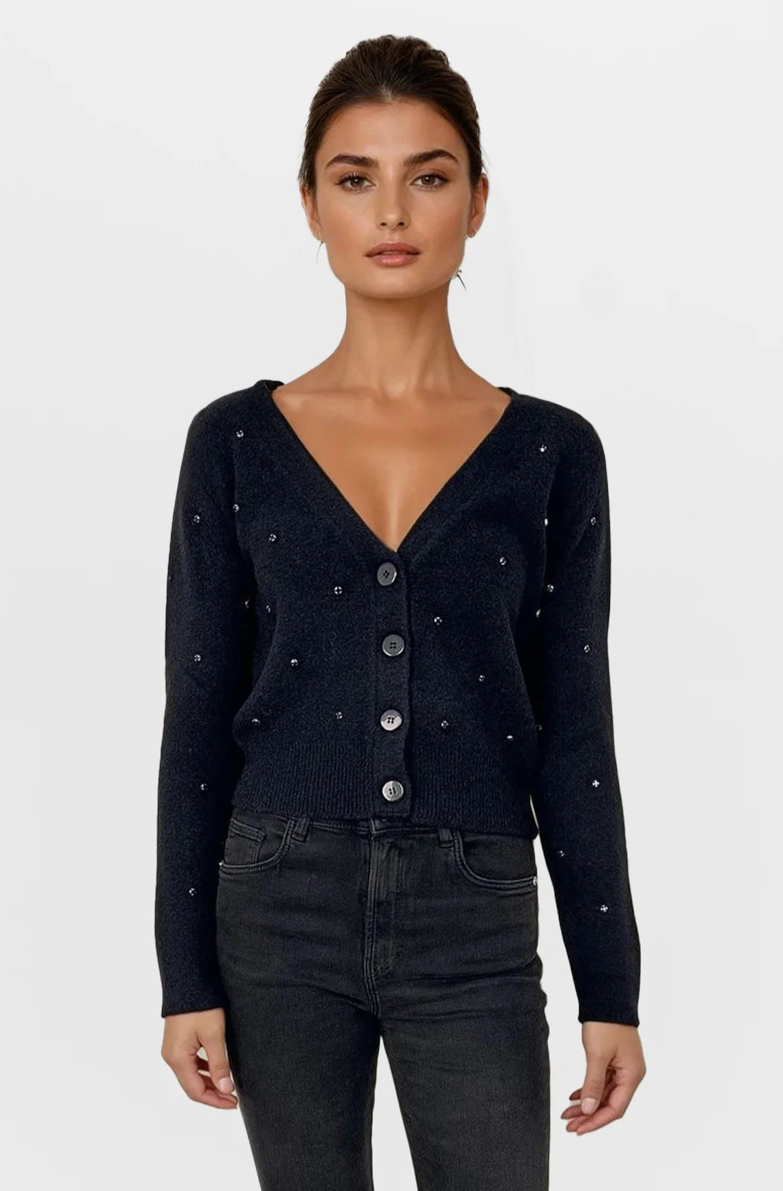 Woman wearing a black cardigan with button details on a white background