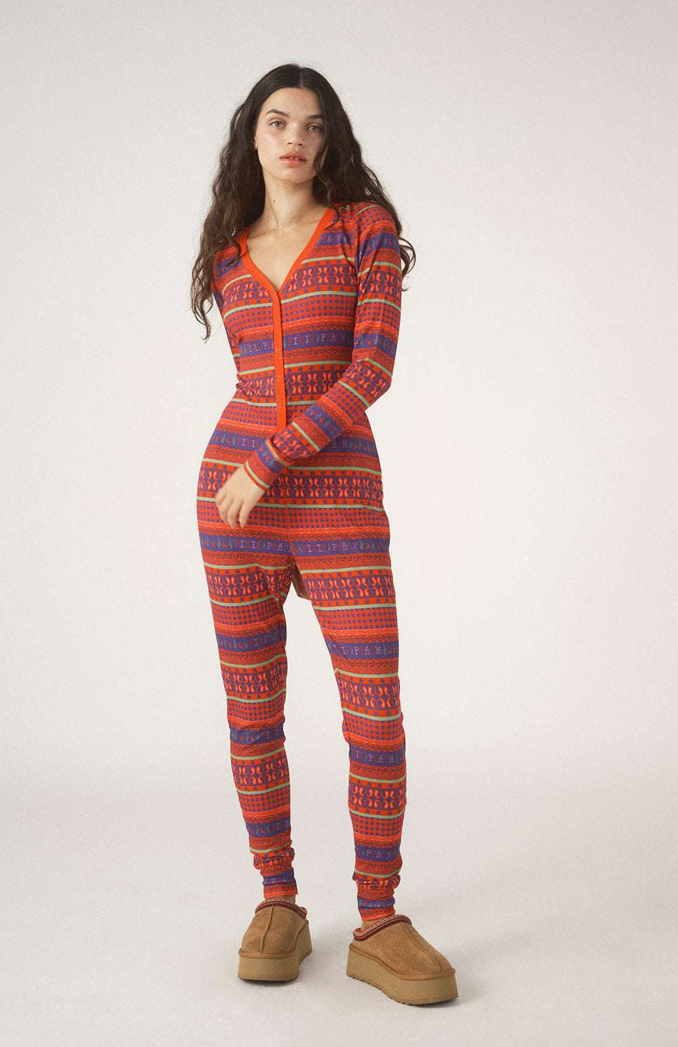 Person wearing a red and blue patterned onesie on a white background