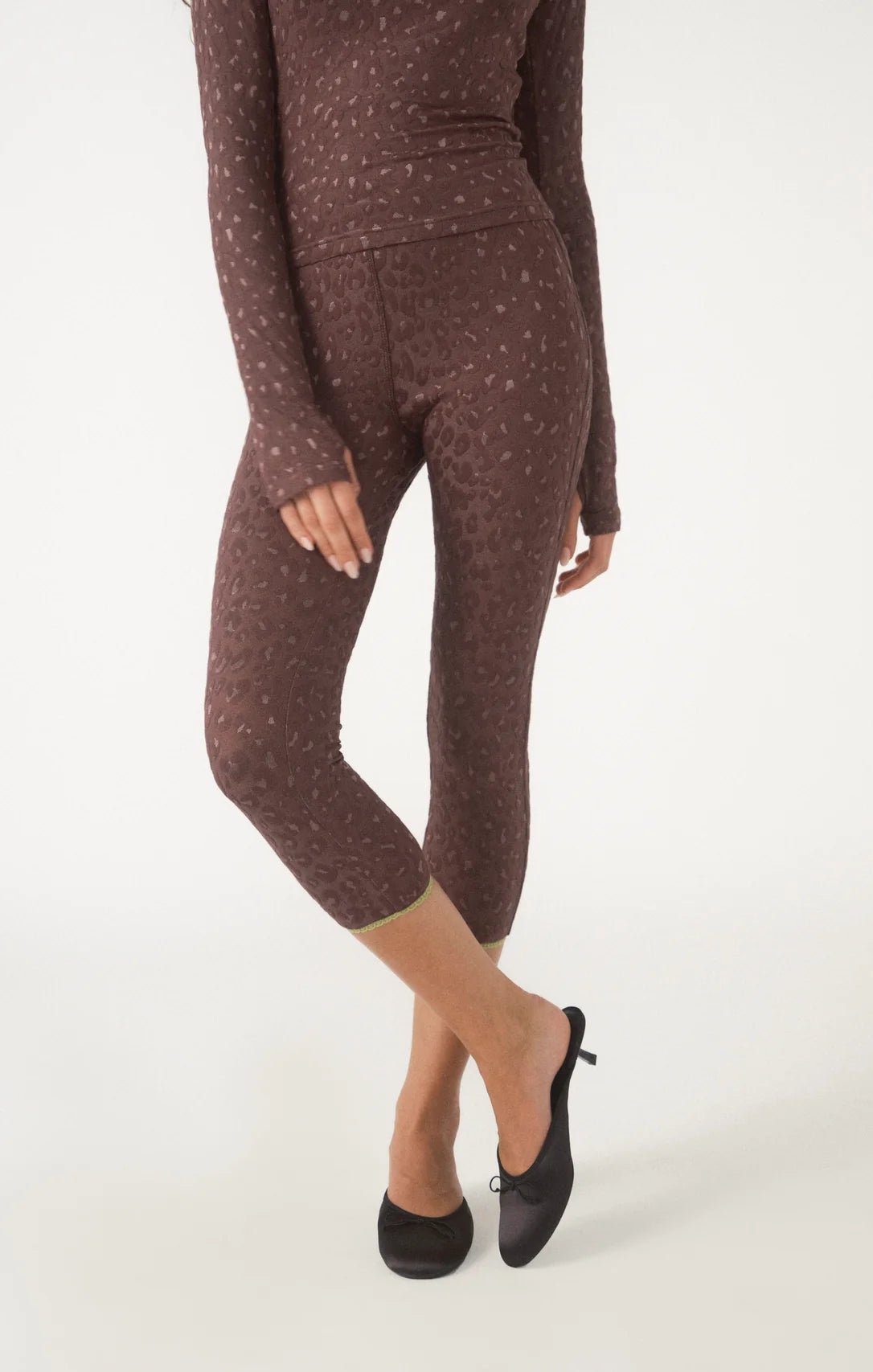 Brown polka dot leggings worn by a person on a white background