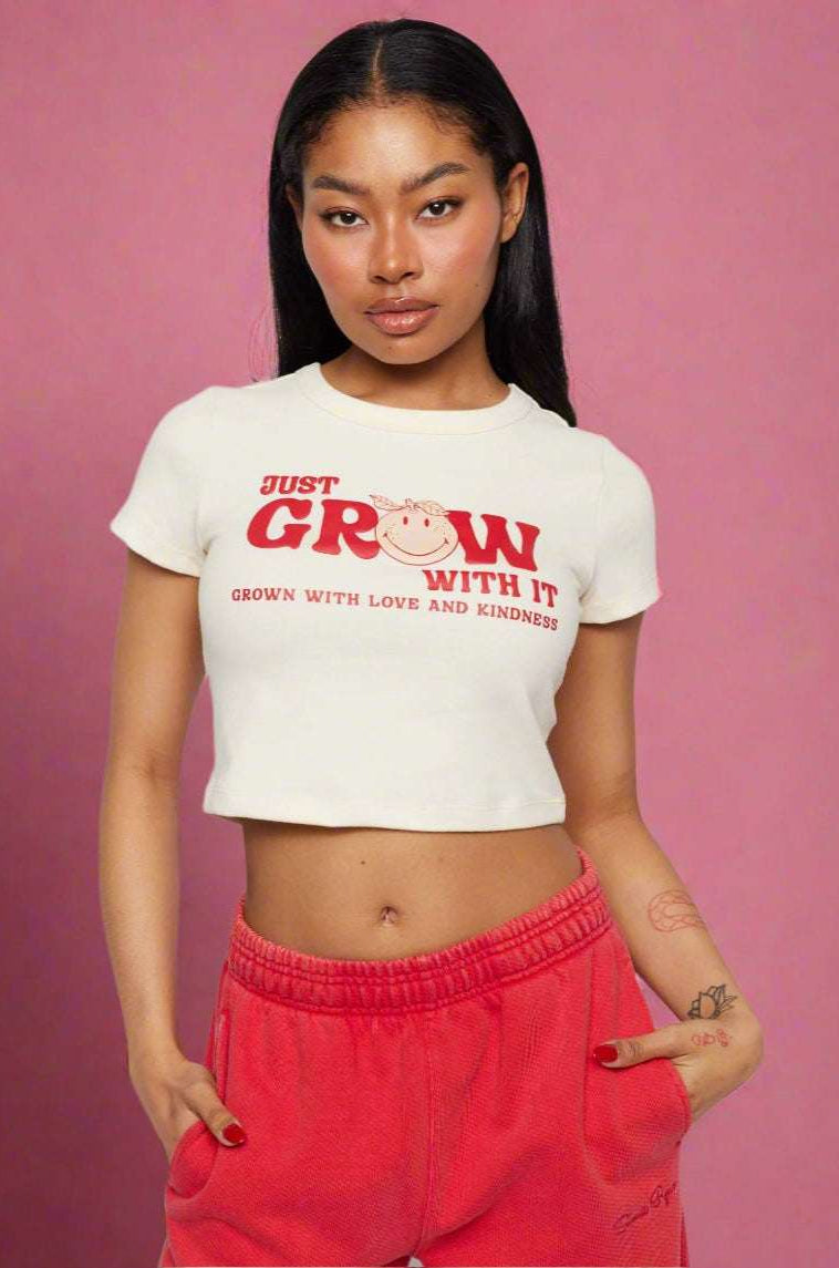 Samii Ryan x Smileyworld® Just Grow With It Baby Tee T-Shirt by Samii Ryan as seen on celebrities
