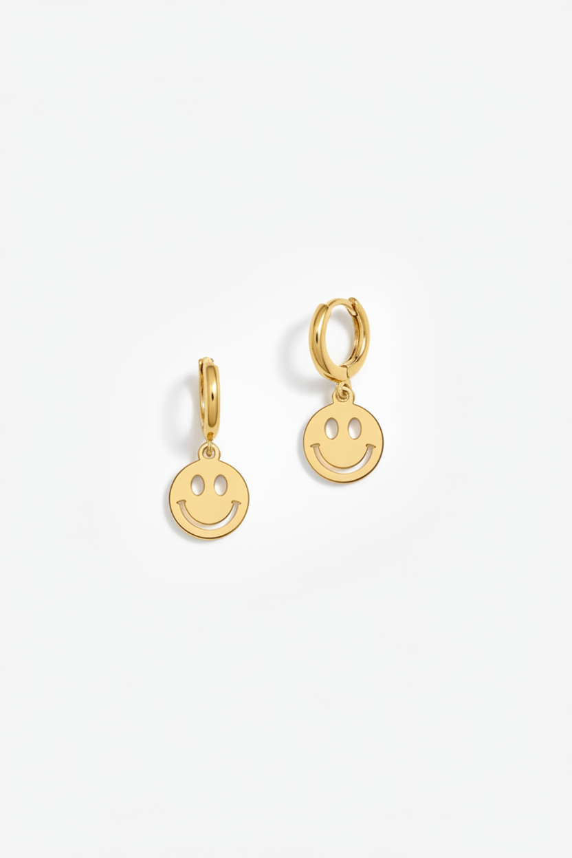 Gold smiley face earrings on a white background