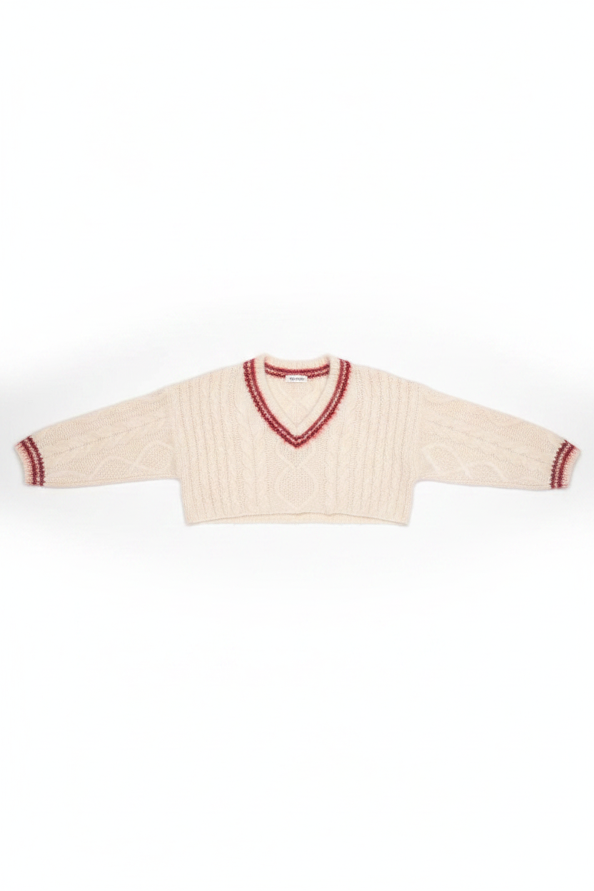 Cream-colored sweater with red trim on a white background