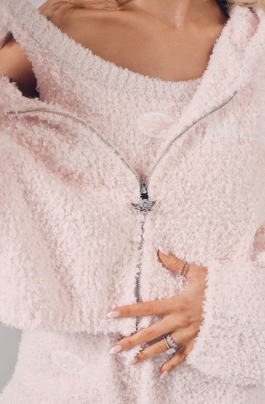 Close-up of a person wearing a fluffy white coat with a blurred background