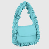 A light blue ruffled shoulder bag with a structured flap front, photographed against a solid light gray background.