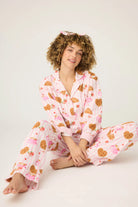 Woman wearing pink pajamas with heart patterns on a white background