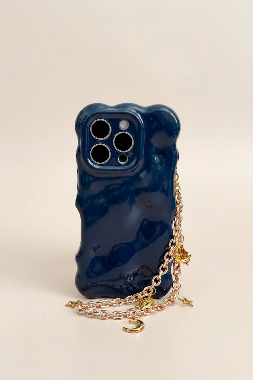 Blue phone case with a gold chain on a beige background