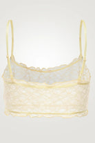 Yellow lace bralette on a light gray background