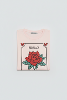 Pink t-shirt with a red rose graphic on a white background