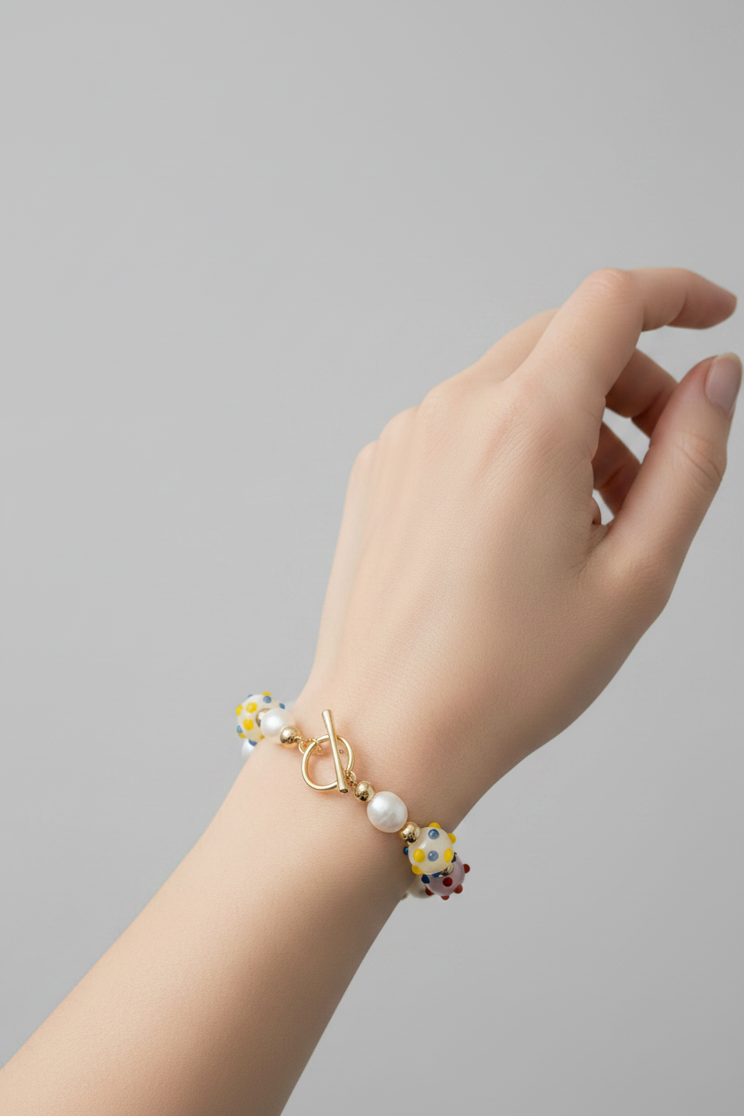 Hand wearing a colorful beaded bracelet by 8 other reasons on a gray background